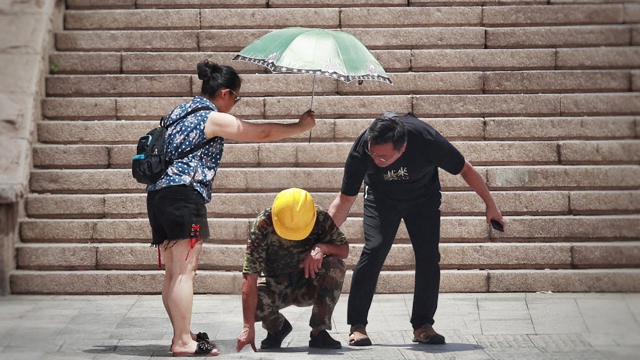 When a migrant worker fainted by the roadside because of the heat stroke... 农民工街头中暑晕倒，引来陌生人“组团”相助！