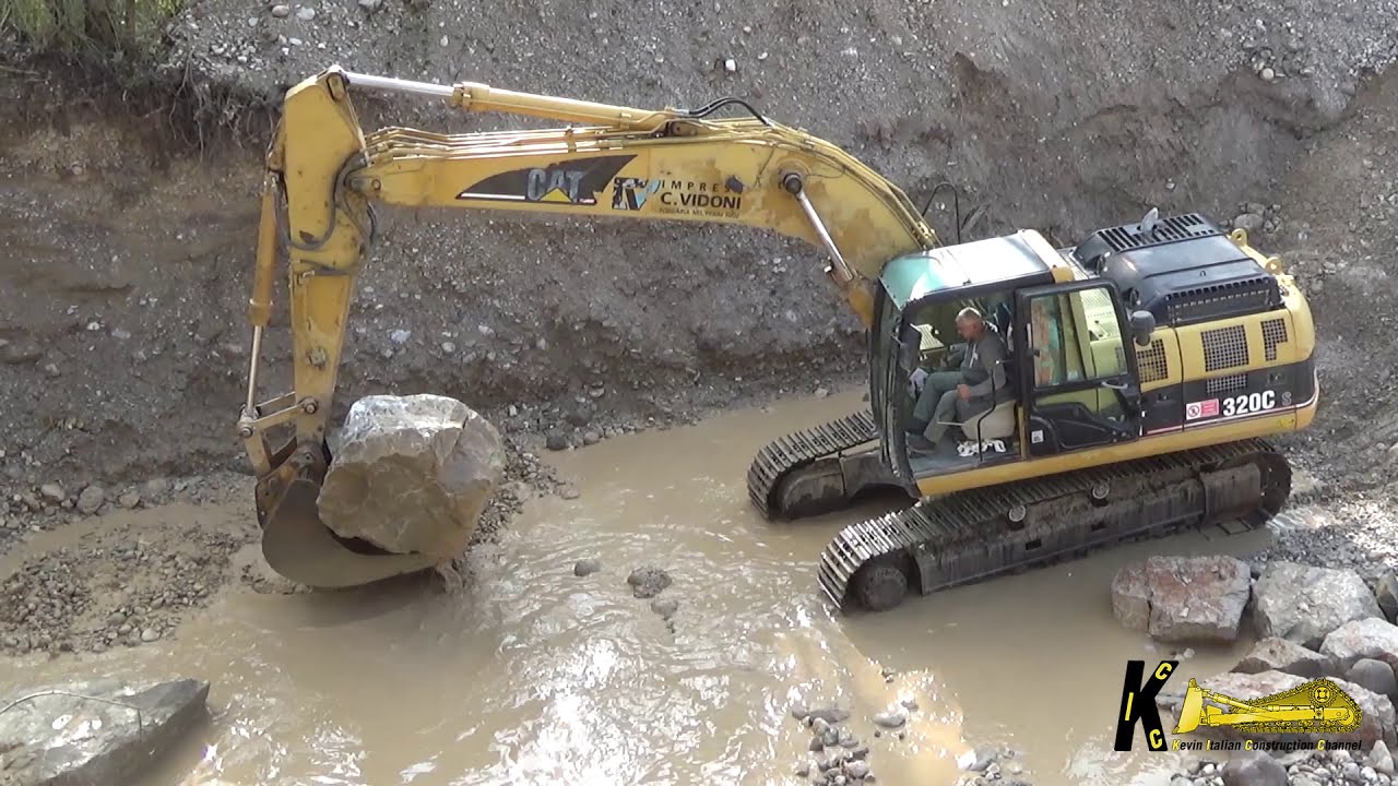 Caterpillar 320C S Excavator Posing Rocks in the River