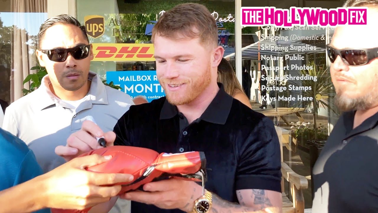 Боксер Канело Альварес окружен фанатами, когда выходит из ресторана Shu Sushi House в Лос-Анджеле...