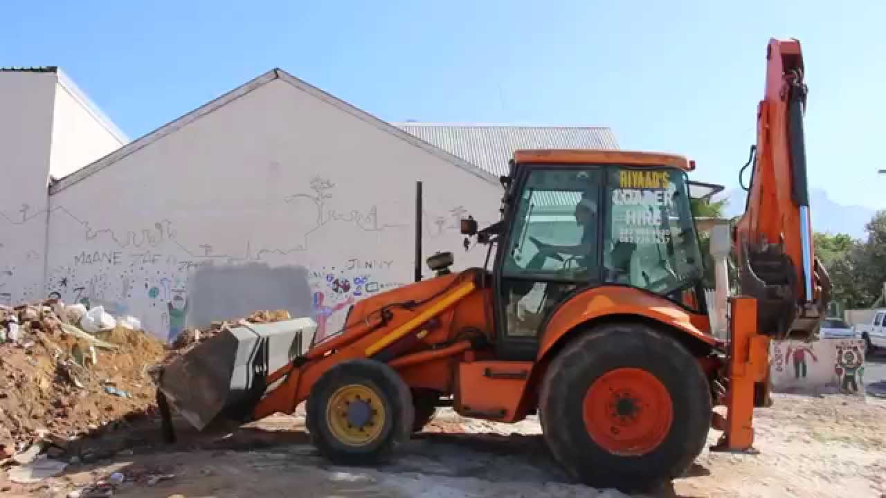 The digger is clearing up the building rubble