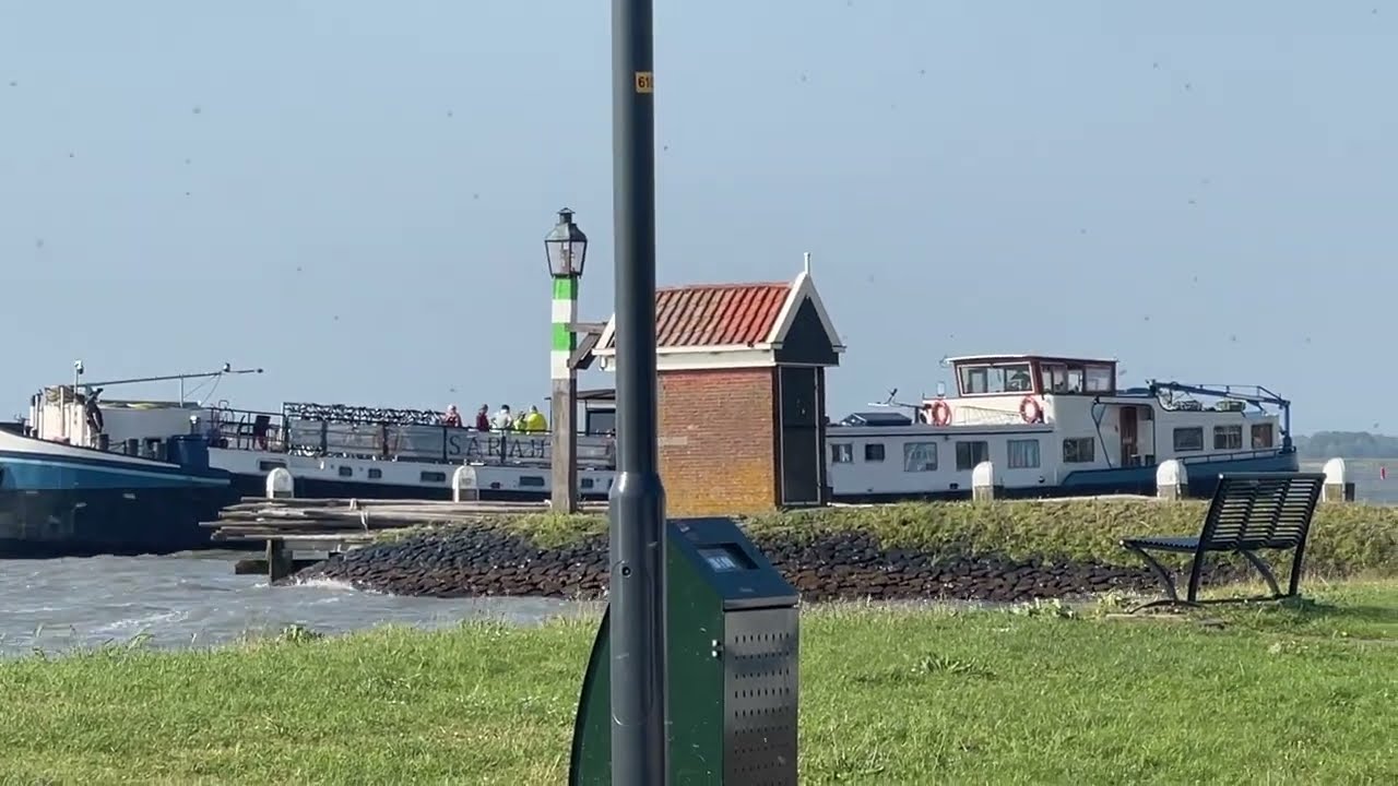 Groot Schip in problemen bij haveningang Volendam door harde wind op zijkant.