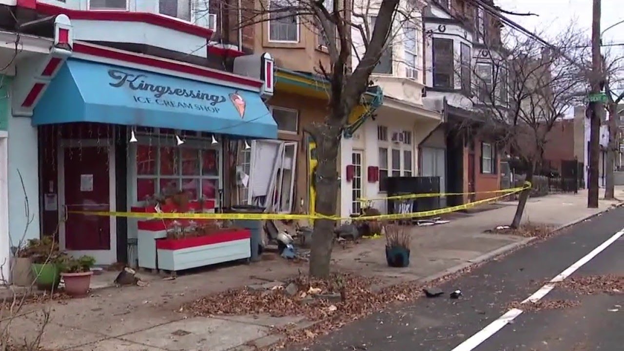 Car crashes into South Philly business, home