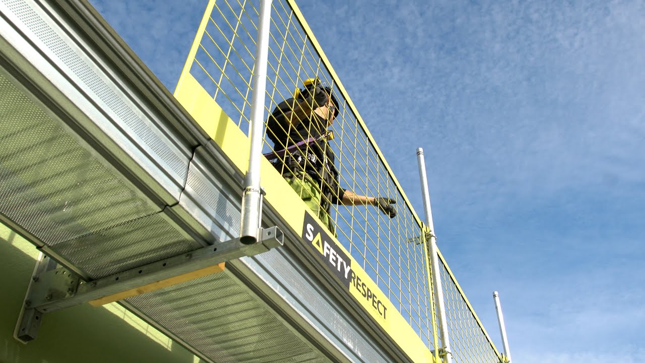 Working platform with temporary edge protection for facades and roofs at construction sites