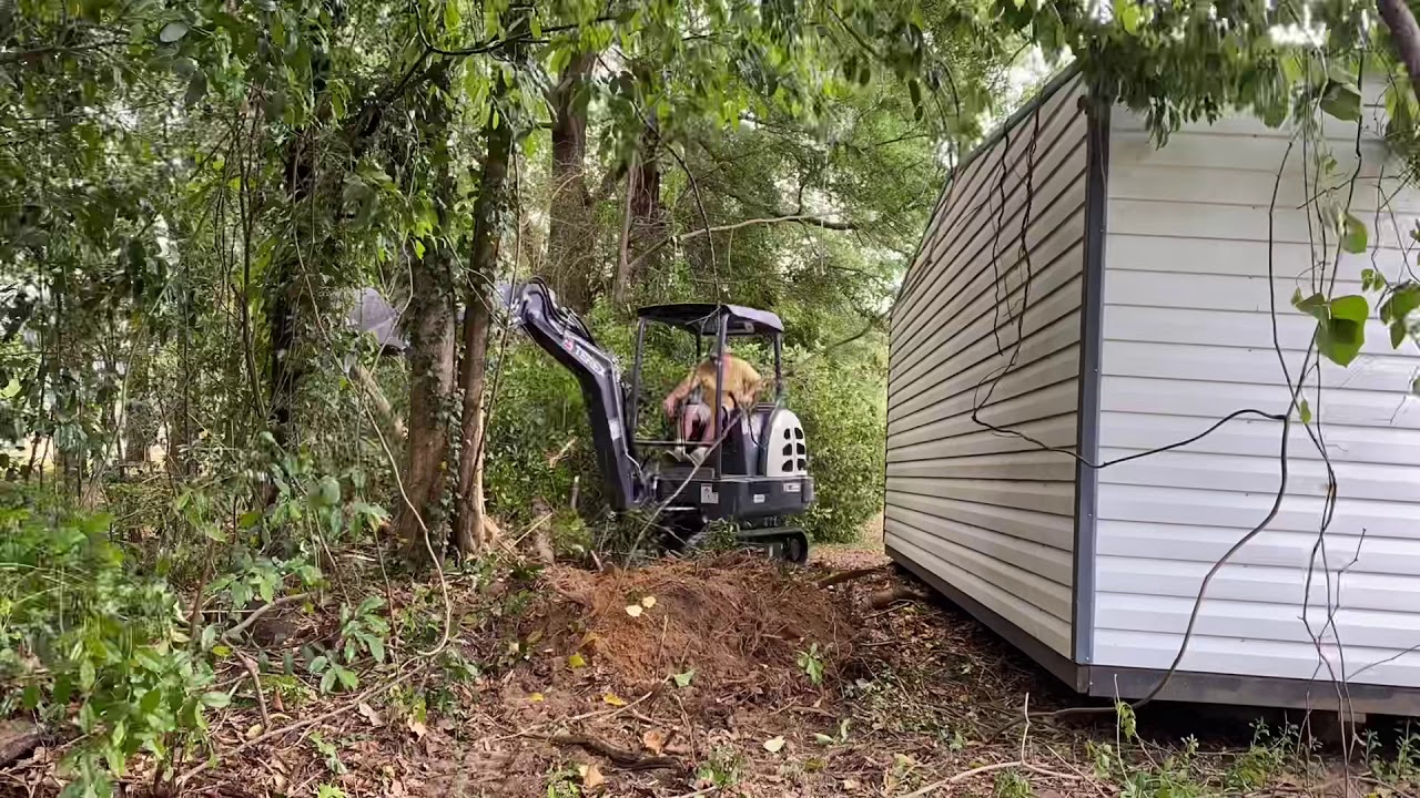 Mini excavator clearing a land line