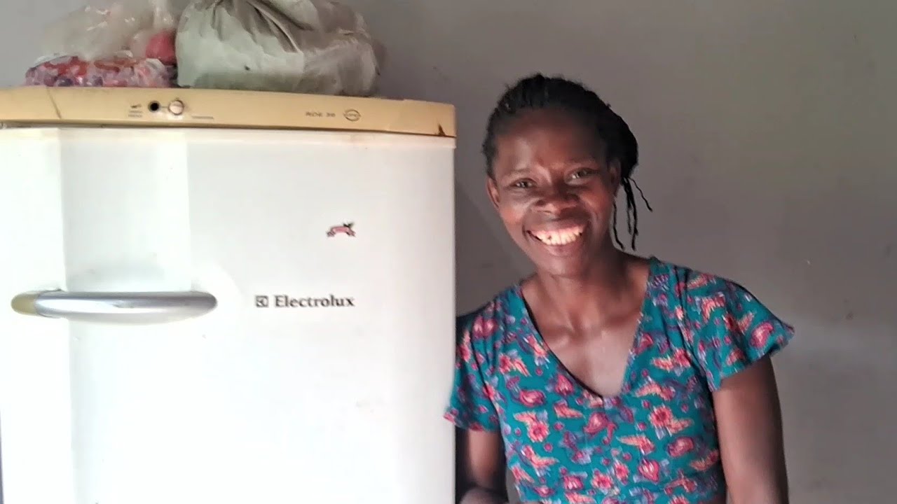 Edineide  fazendo suco de acerola para as crianças 