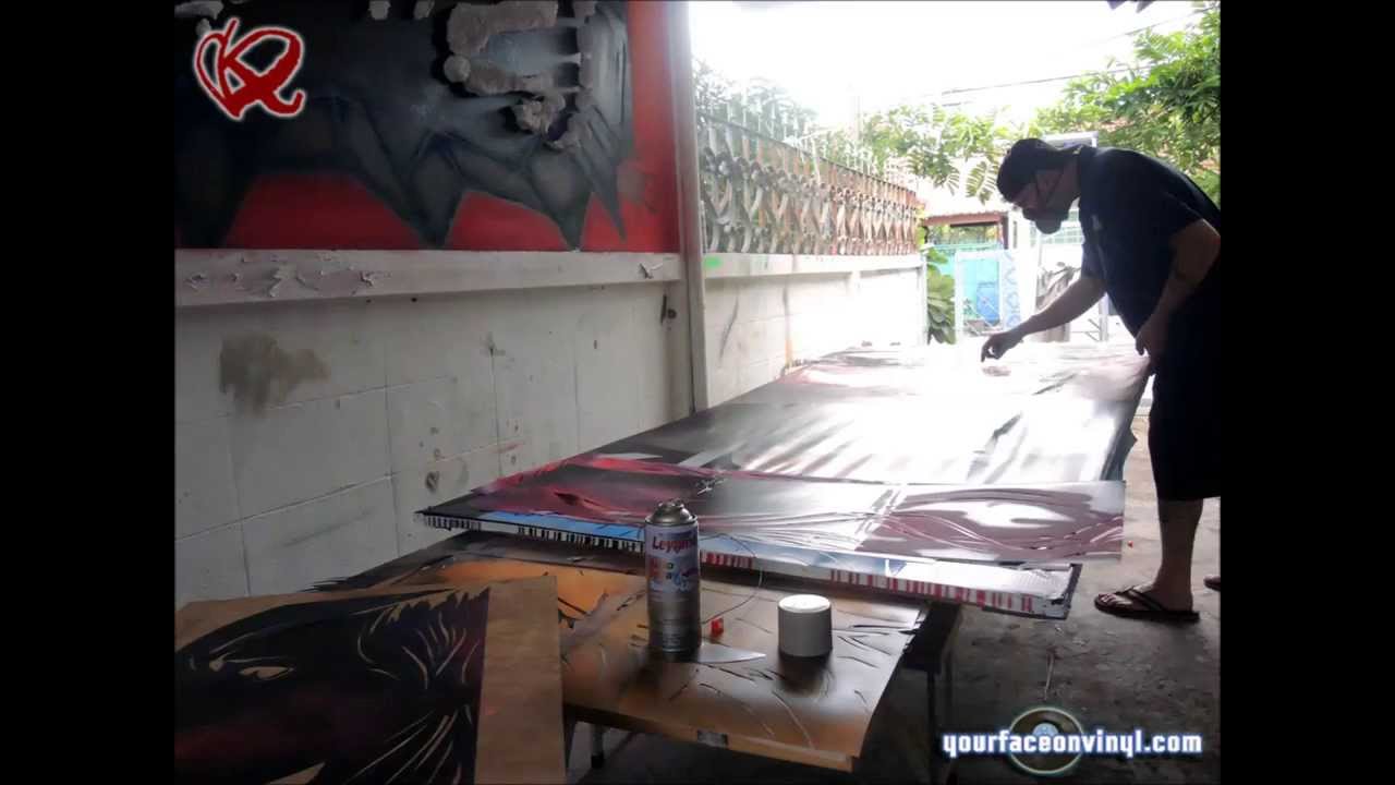 Artist working on big Angel art stencil in studio