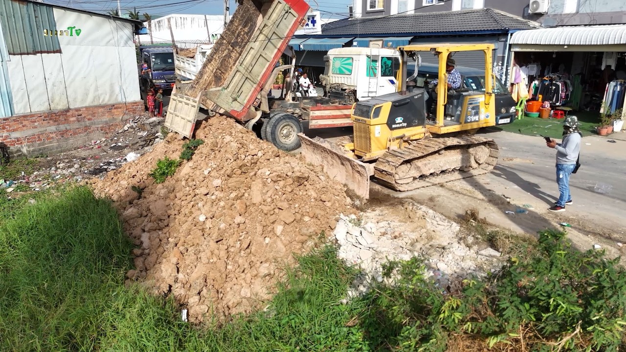 Great Start Land filling action bulldozers and dump trucks working perfect coordination, moving soil