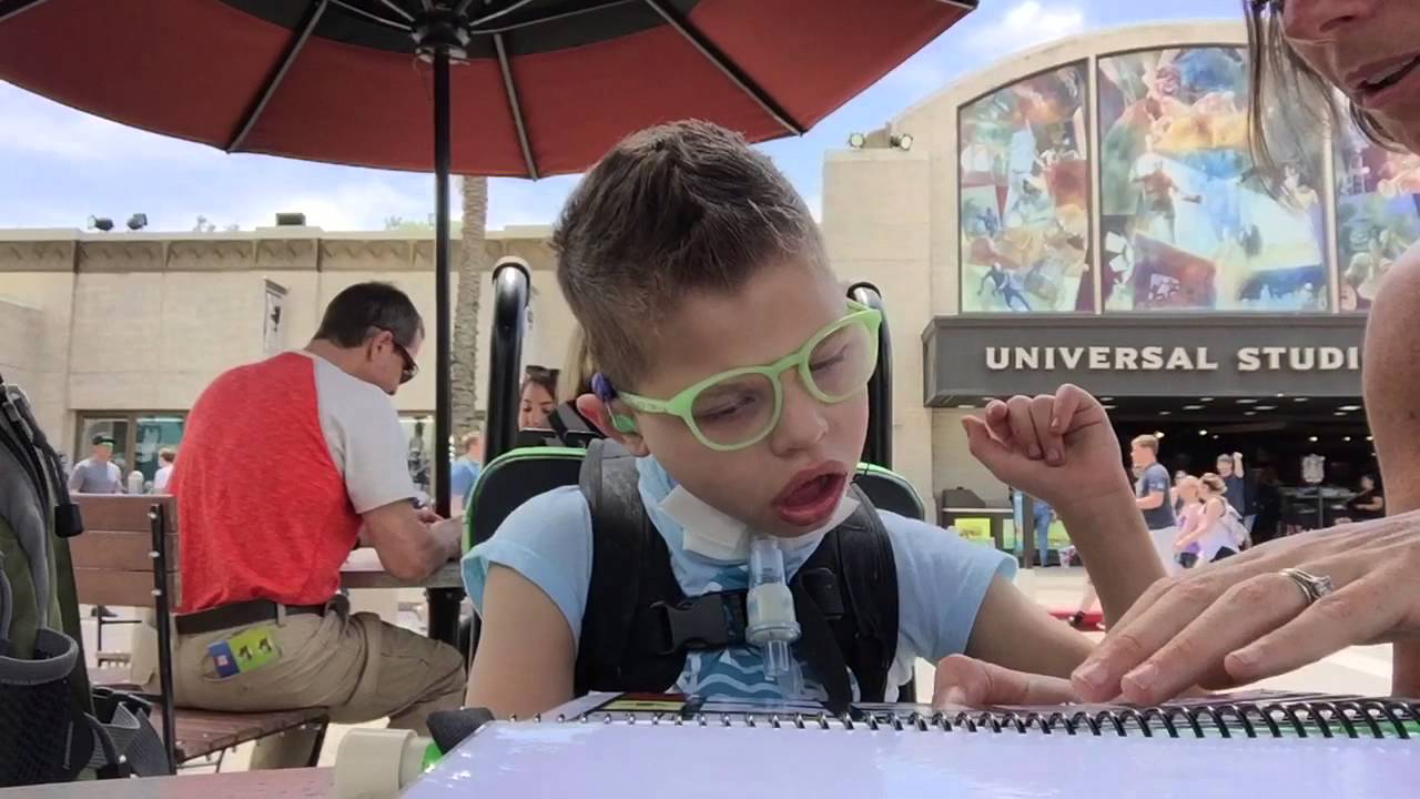 Jayden using PODD to talk at Universal Studios
