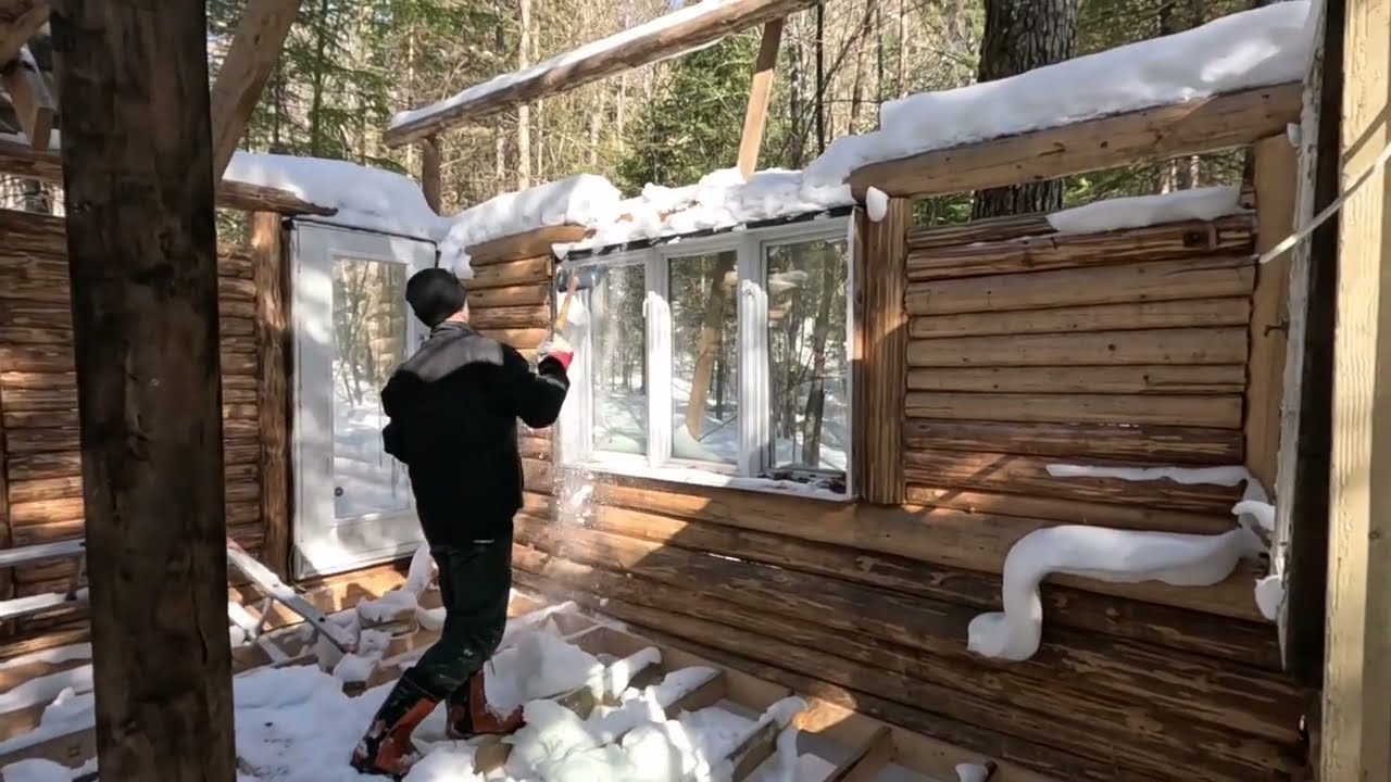 Snow removal from the log cabin under construction 