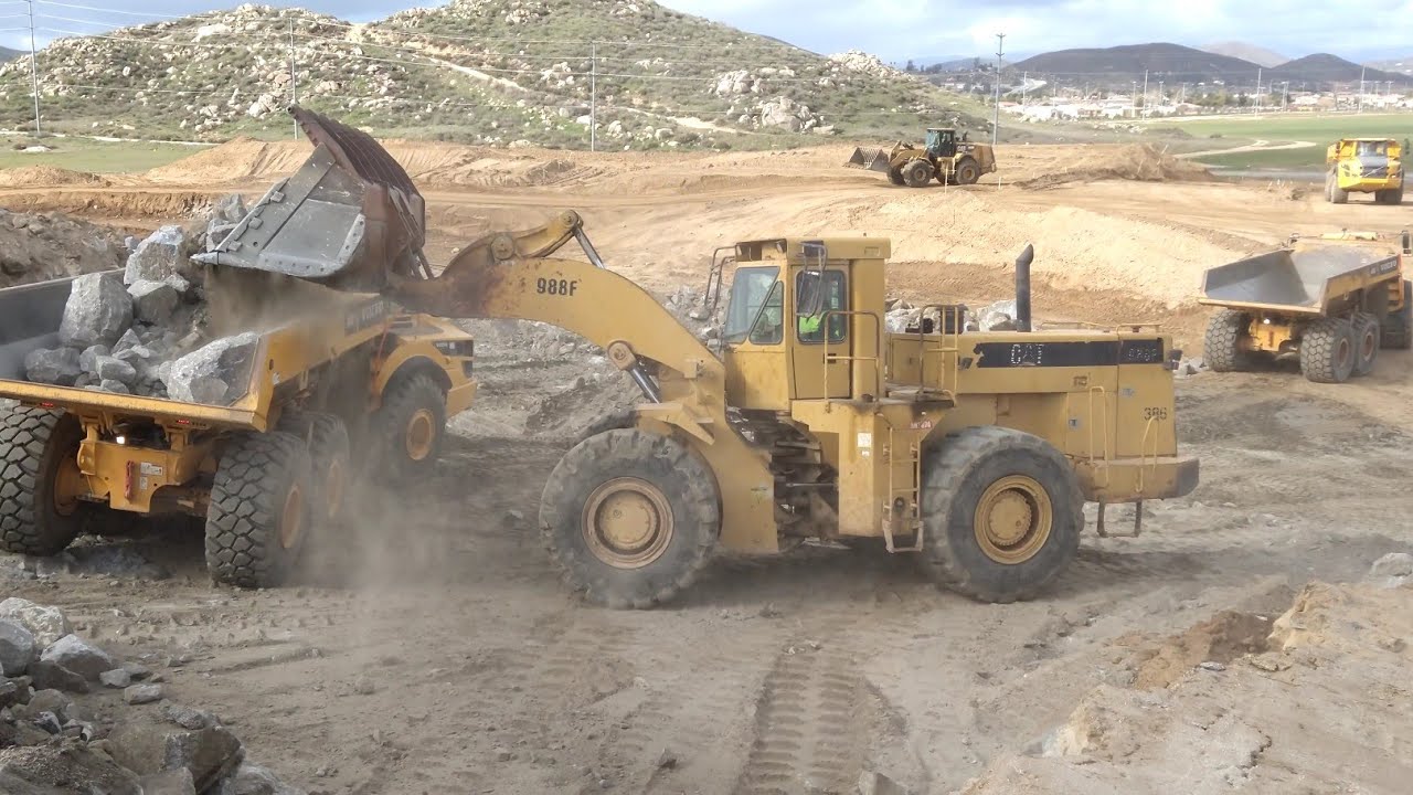 CAT 988F Loader loading Volvo A45G articulated trucks- D10T dozer feeding pile