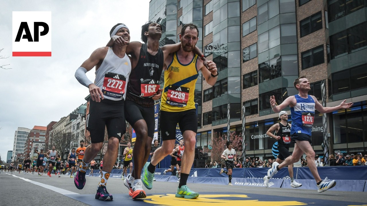 Boston Marathon runners help another runner who collapsed finish the race