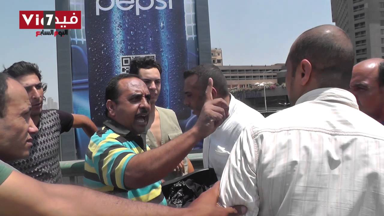 شاب يرتدى زى منتقبة والأهالى يخلعون ملابسه على كوبرى أكتوبر