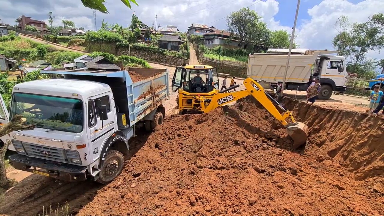 jcb digging and loading soil into a dump truck