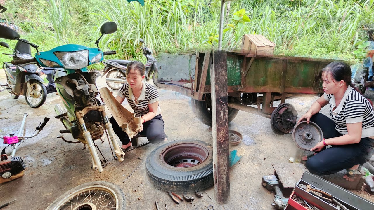 The genius girl changed the tractor bearings and showed the repairman how to fix it.- repair girl