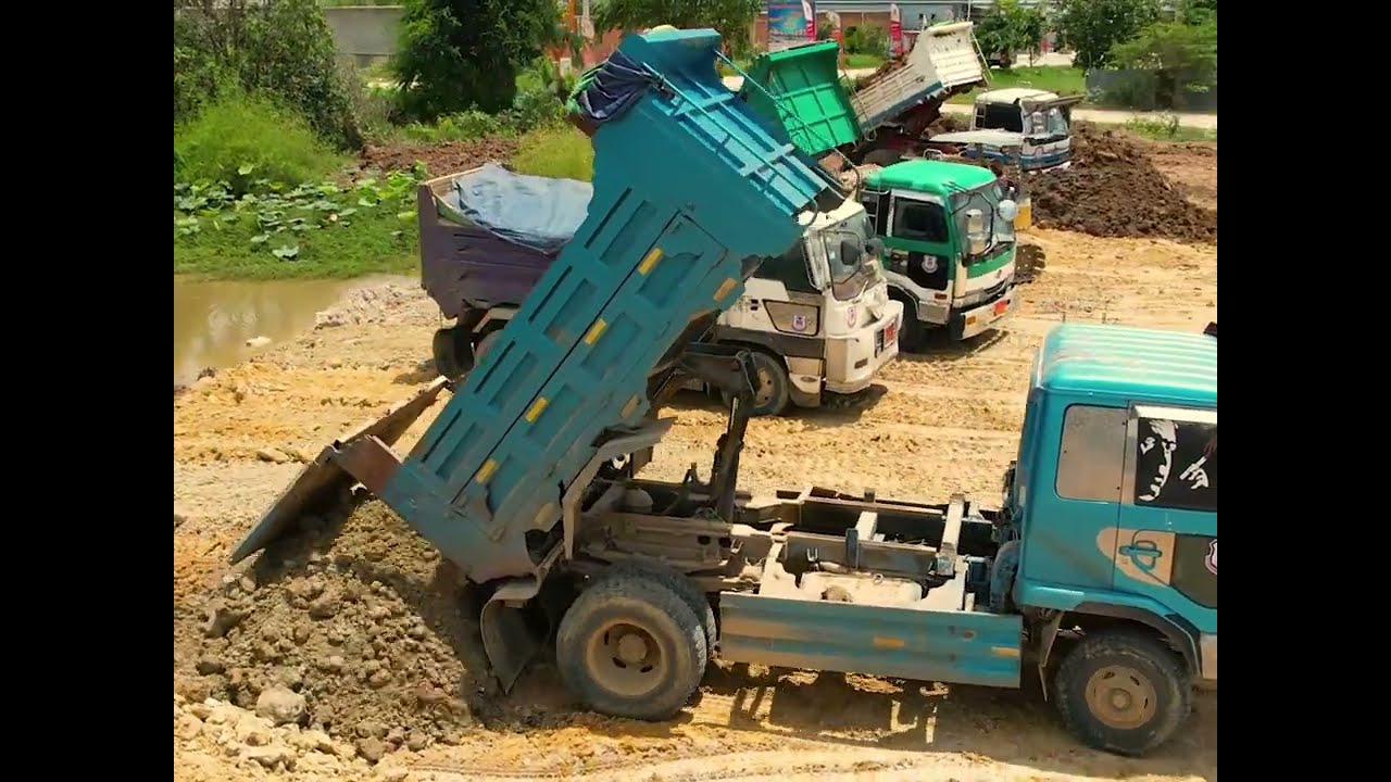 Full Project Dump Trucks Filling Land While Bulldozers Push Massive Soil