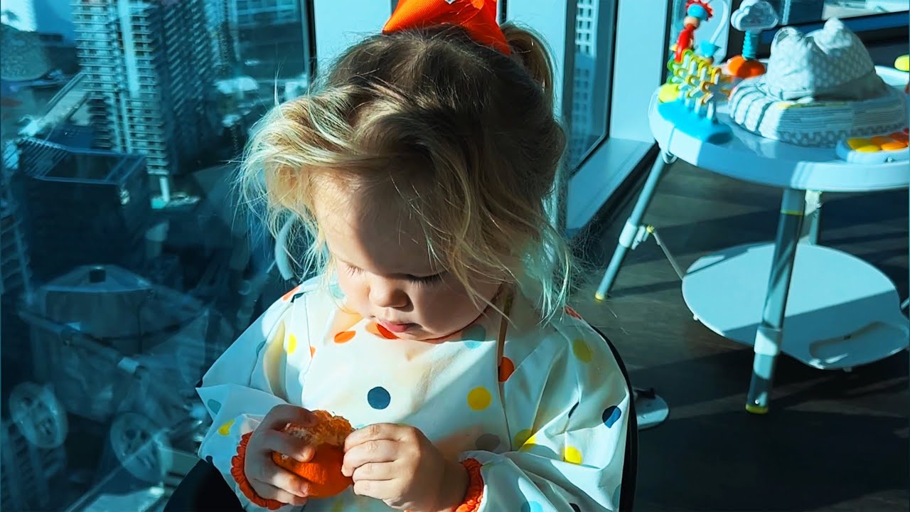 Little toddler Naomi eats tangerine