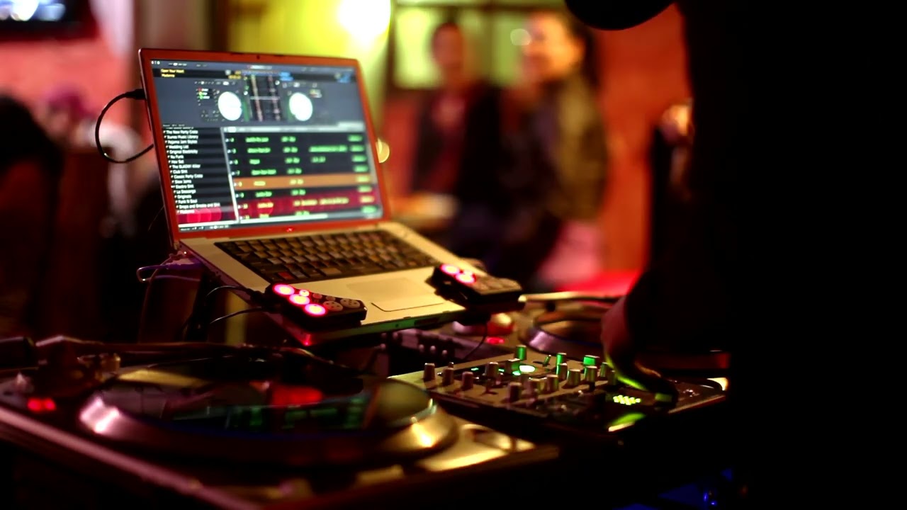 DJ BEHIND THE TURNTABLES WITH A COMPUTER