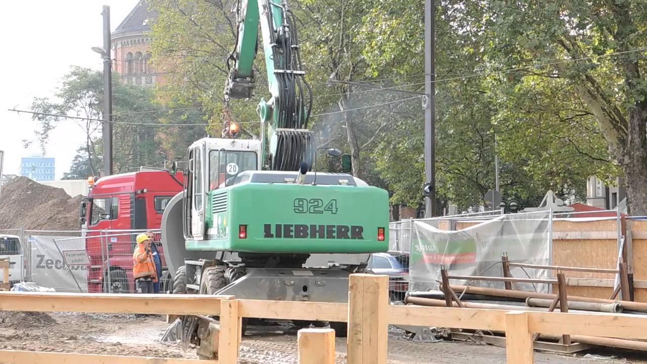 Экскаватор Liebherr 924 выгружает бетонную трубу