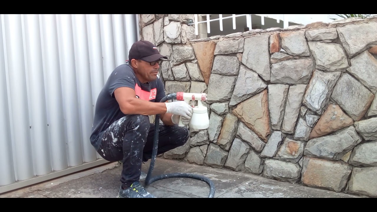 aplicando resina encolor em um muro de pedra
