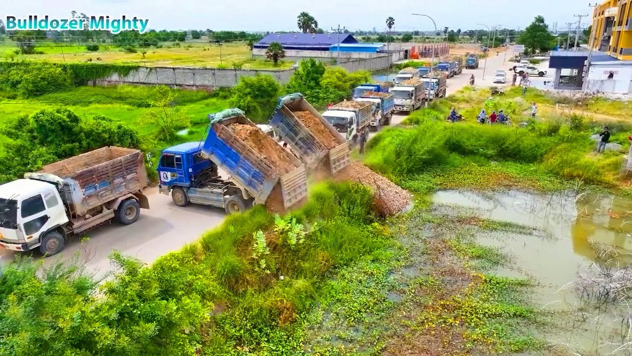 Many trucks preparing to dump soil, Bulldozer KOMATSU DR51PX Working