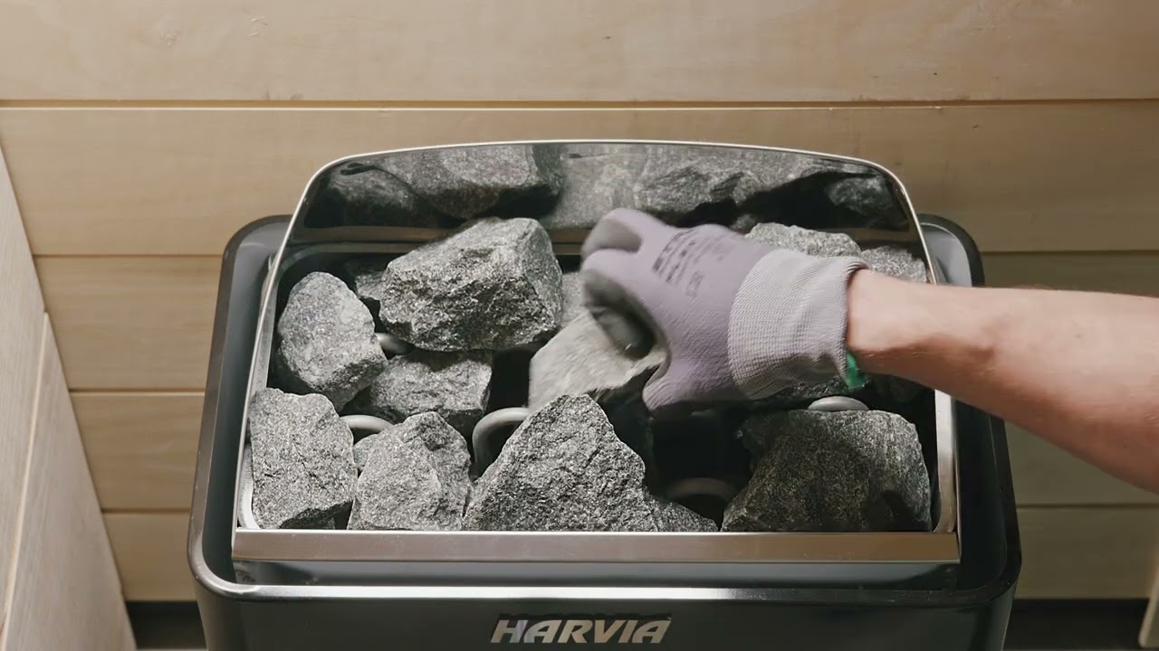 Harvia - Stacking sauna stones into a wall-mounted electric heater