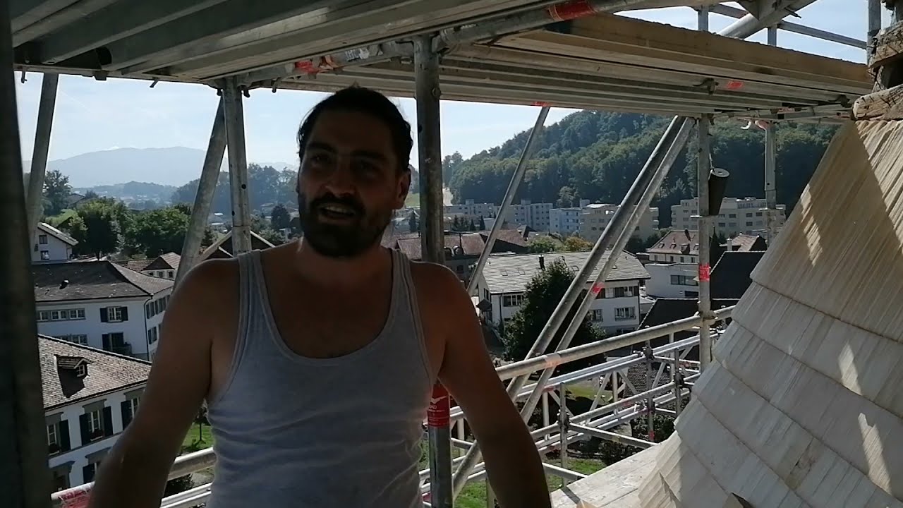 Ein Schindelmacher zeigt, wie er Holzschindeln verlegt
