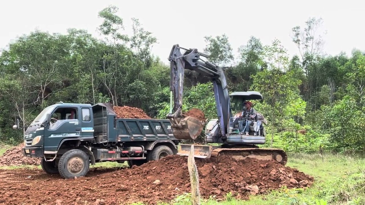 Xe múc xúc đất lên xe tải nhỏ, công việc hằng ngày làm vì đam mê.