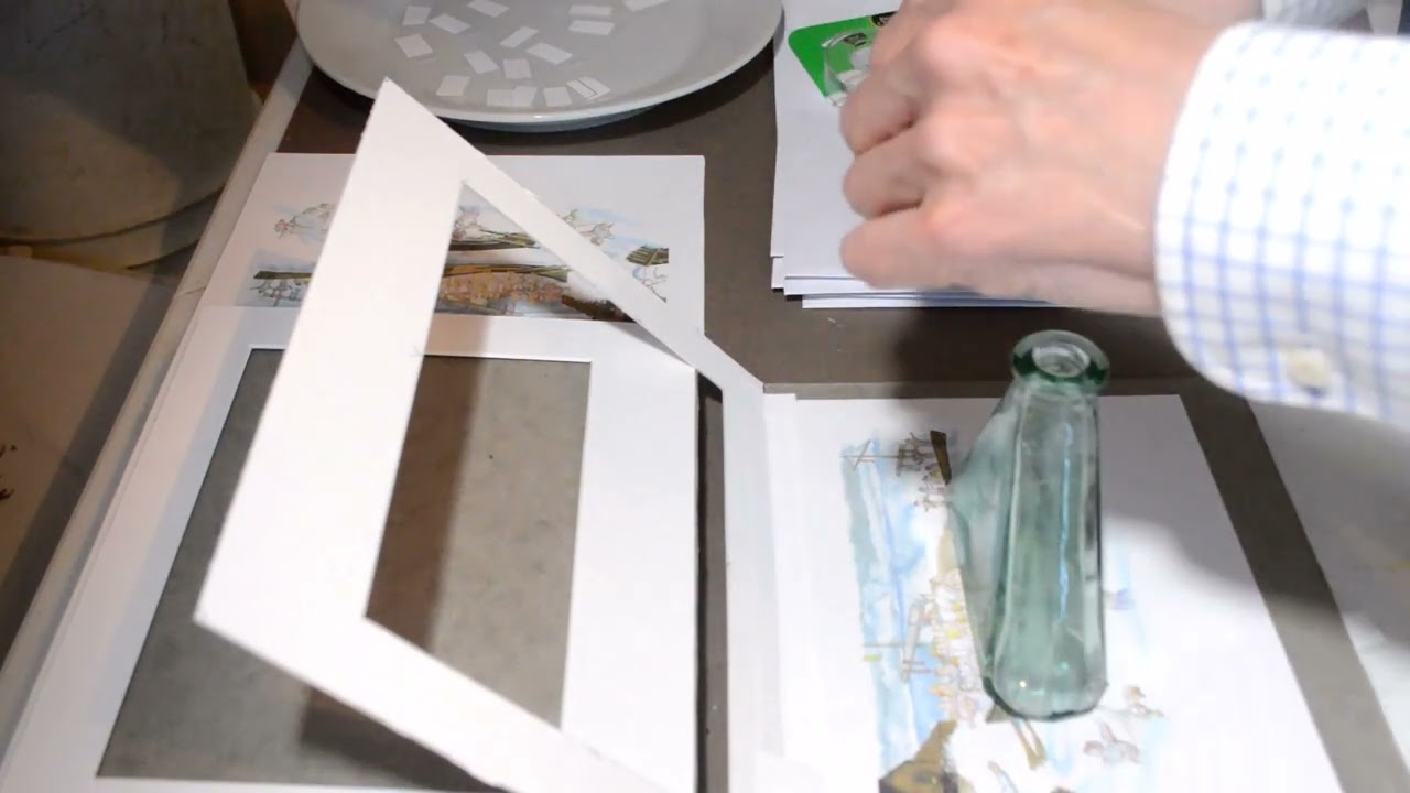 Installing a print in a mat board frame using T hinges for print conservation.