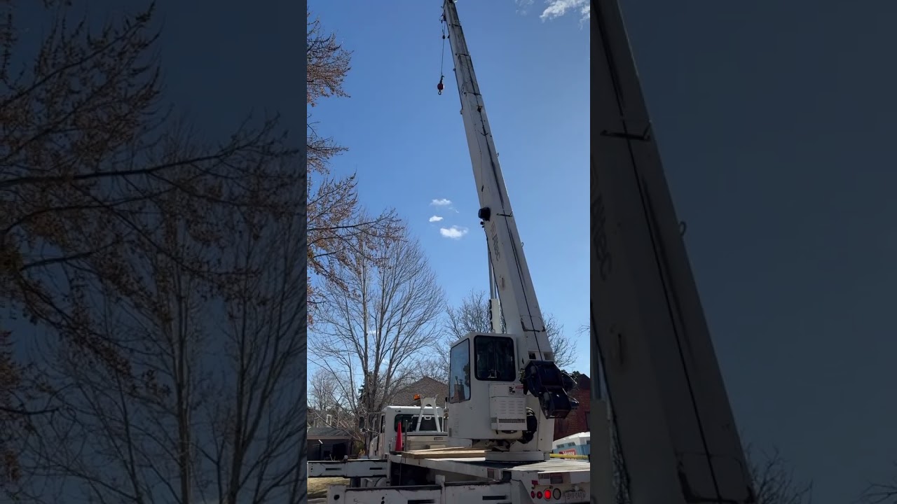 A massive crane delivers a 30 ft steel I-beam to our custom home project in Denver. 