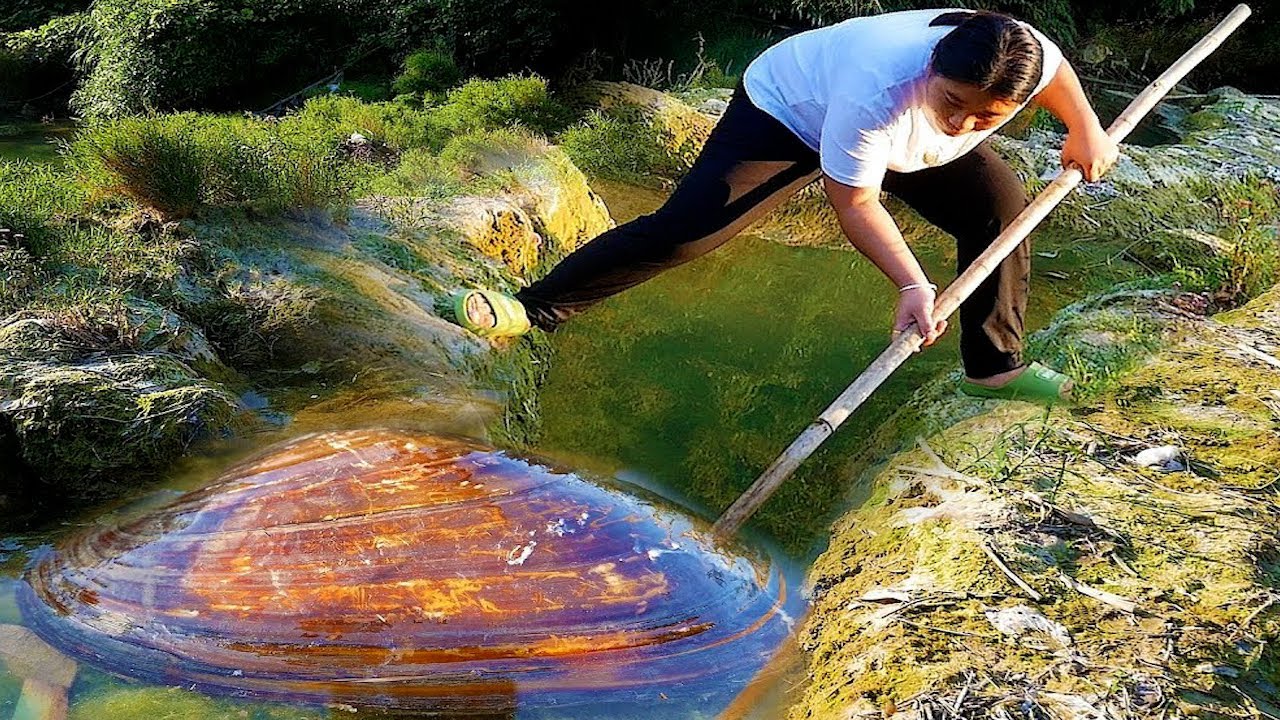 The girl lifted the clam with a bamboo pole over her shoulder and back