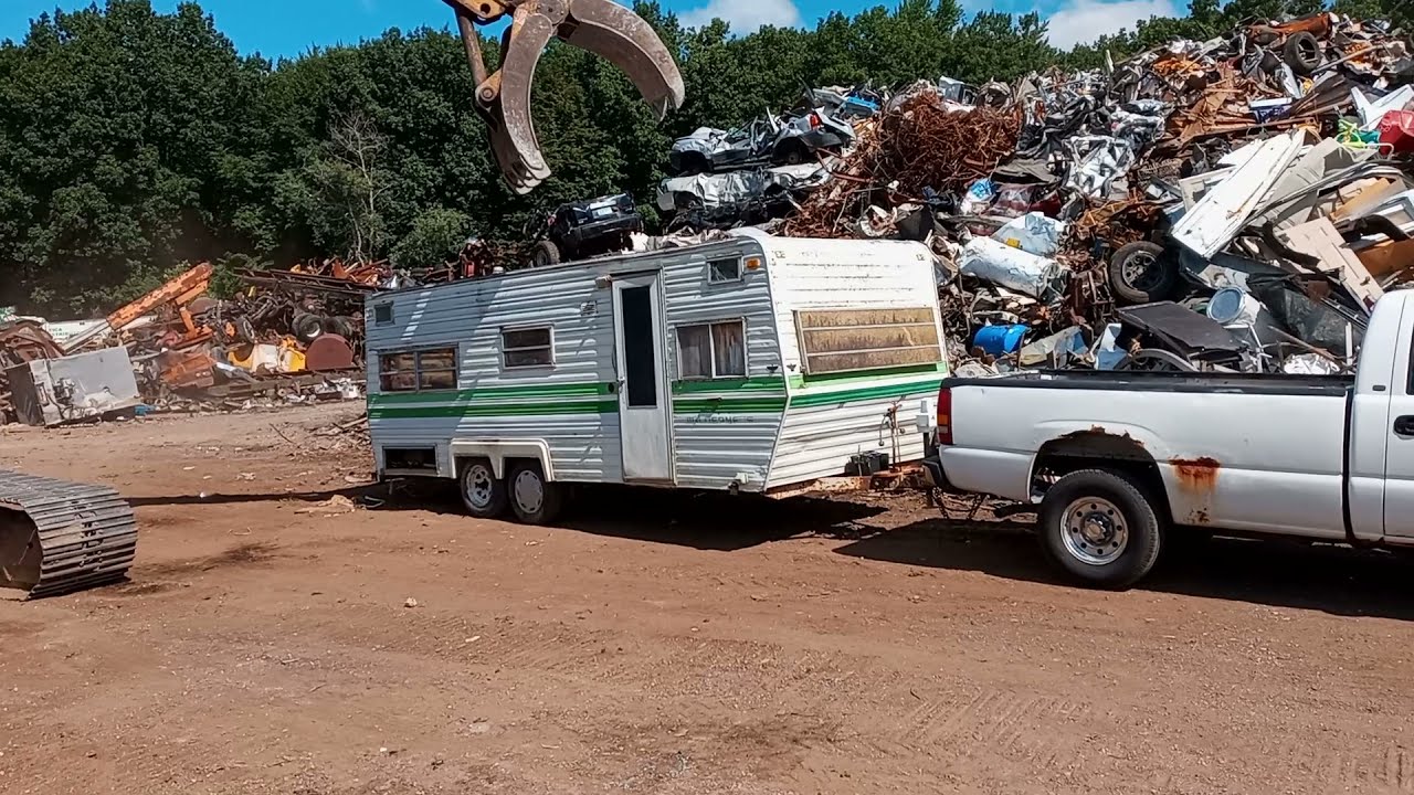 Destruction of a travel trailer RV at scrapyard scrap metal trailer