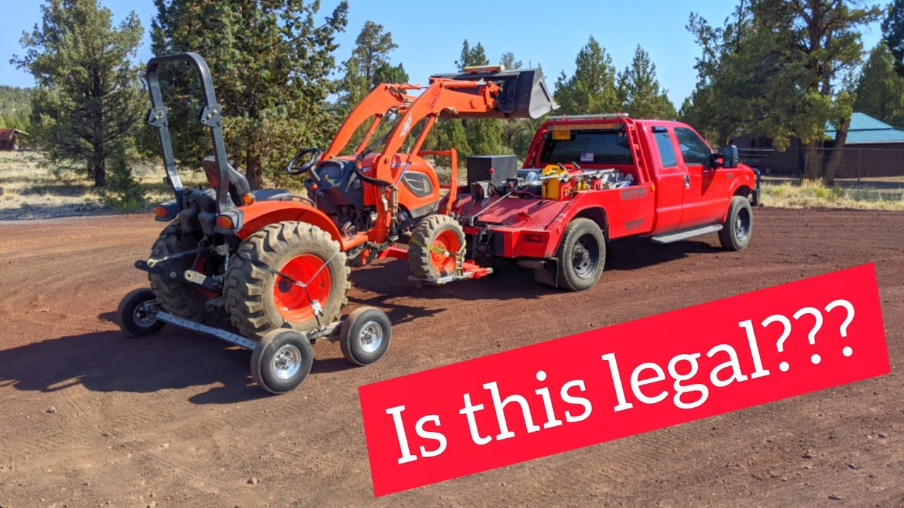 Towing a broken tractor with a tow truck!