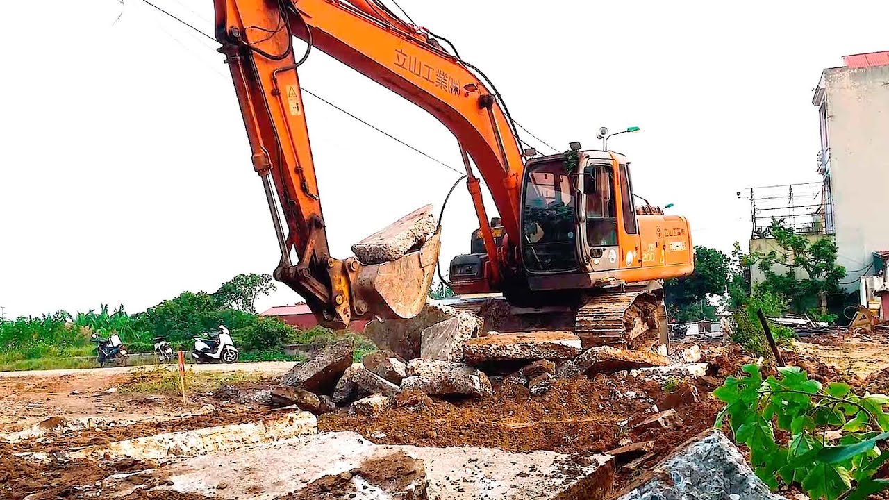 Hitachi excavators demolish concrete roads, excavators scoop up trash along the riverbank.