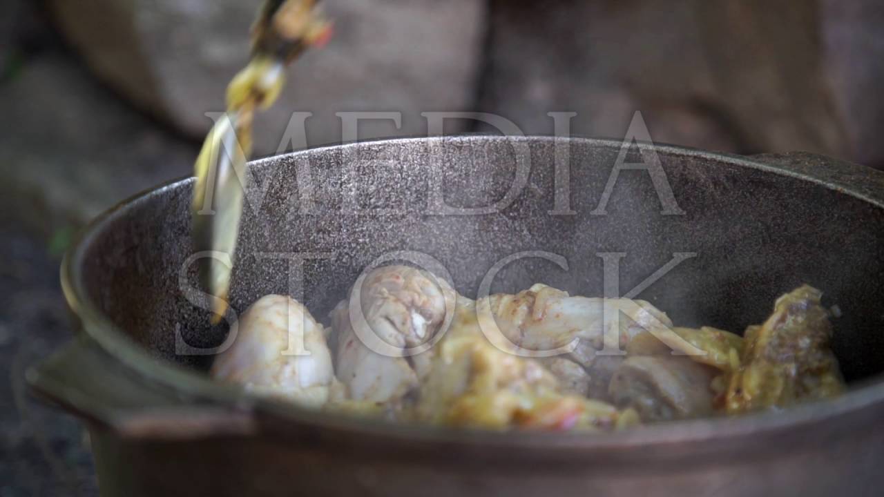 Cooking pilaf on an open fire in a metal cauldron
