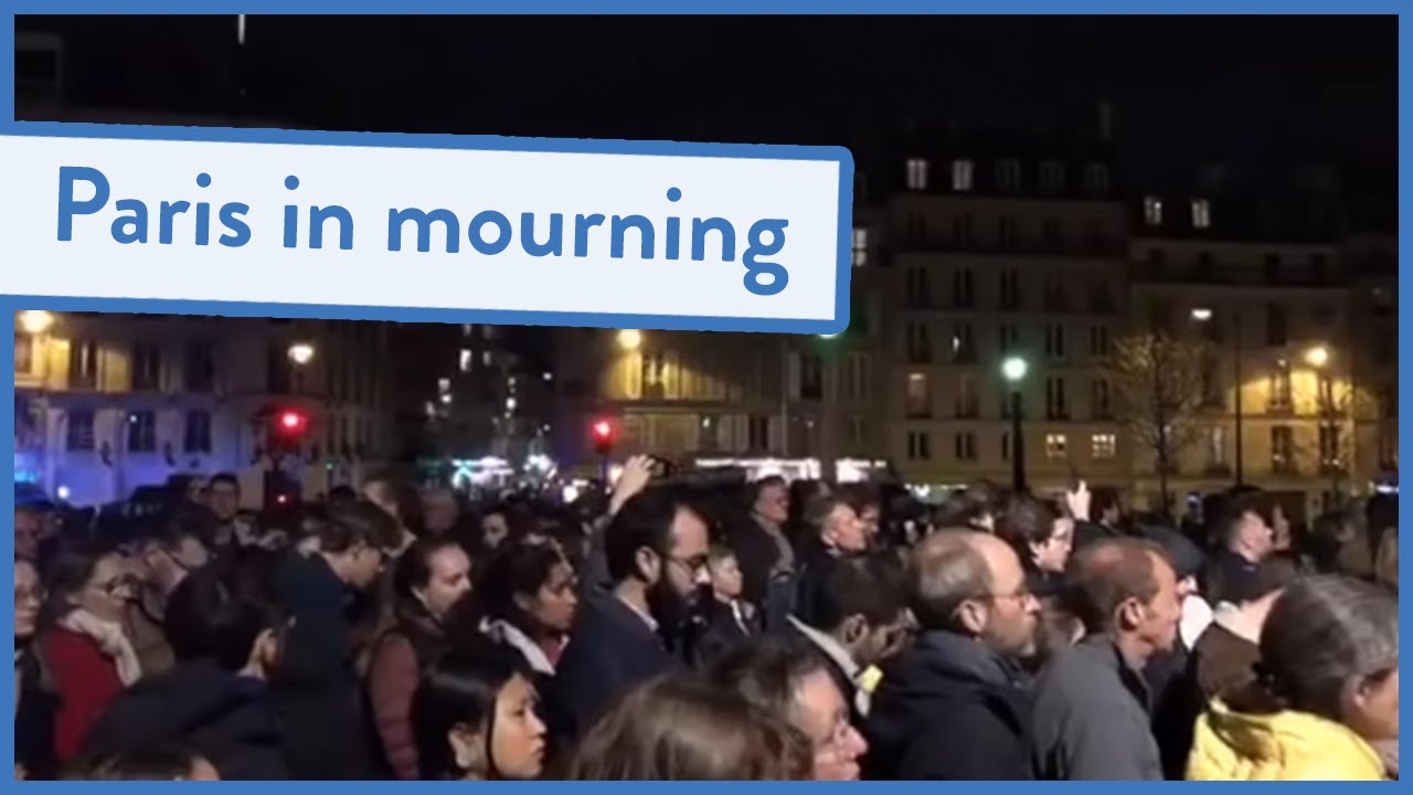Parisians sing as the Notre Dame cathedral burns