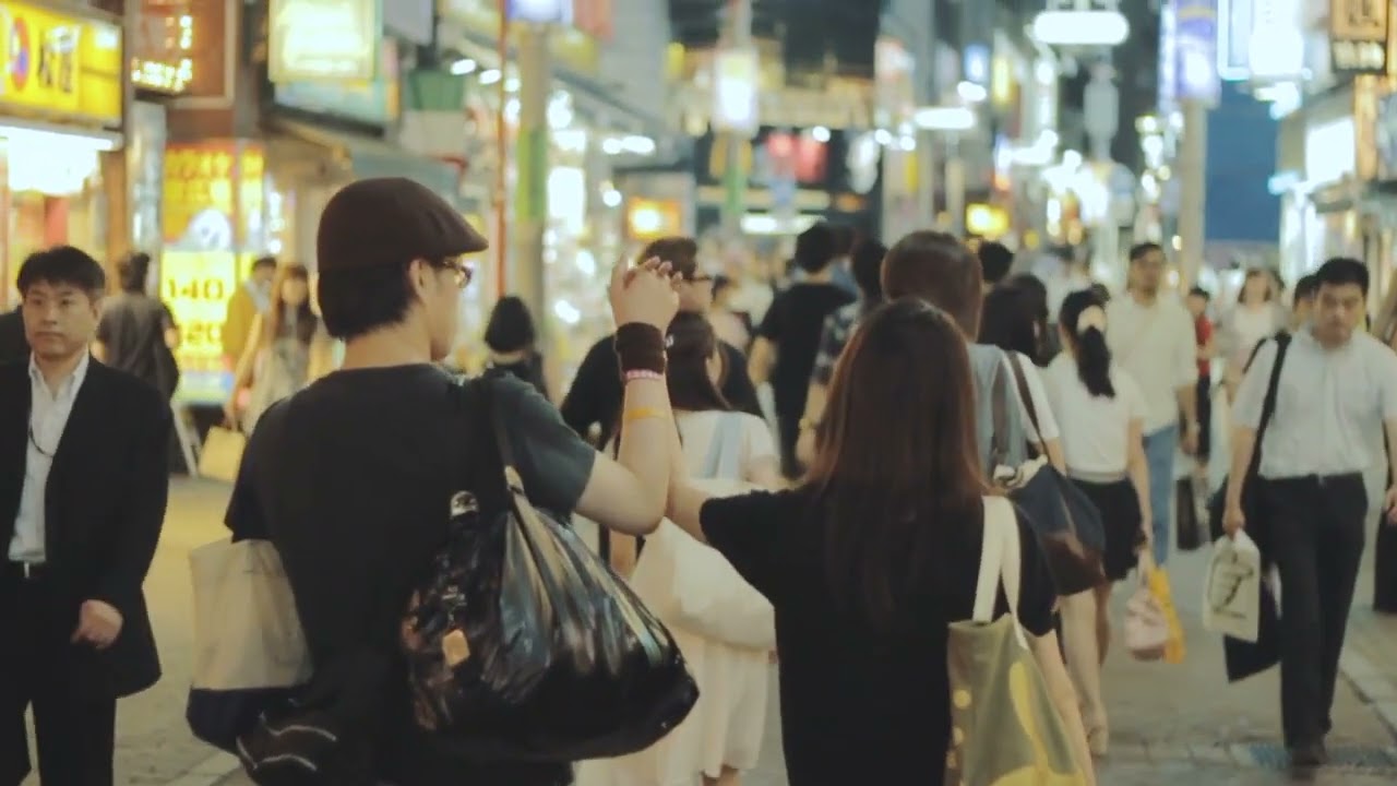 Couple Holding Hands While Walking on a Busy Street Akihabara