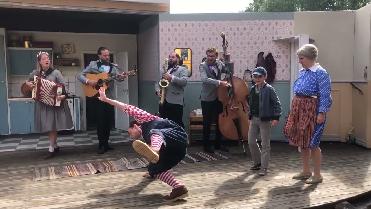 Karlsson, lillebror och fröken Bock dansar till orkester. Karlsson på taket. Astrid Lindgrens värld
