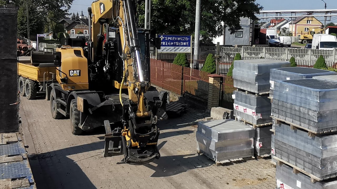 Cat M317F tiltrotator Engcon prace brukarskie - ustawianie krawężnika i układanie chodnika