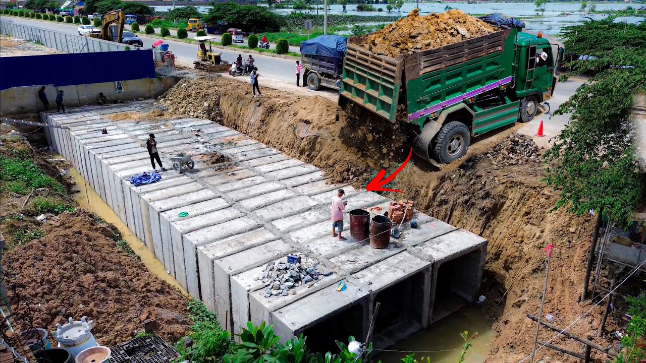 Amazing new project! A dump truck is unloading soil to fill a concrete pipe with Komatsu D20P dozer