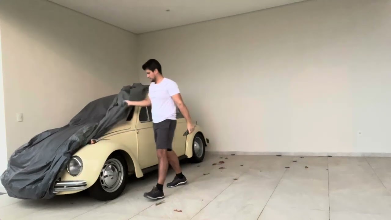 Removing the cover from the old car parked in garage for 30 days.