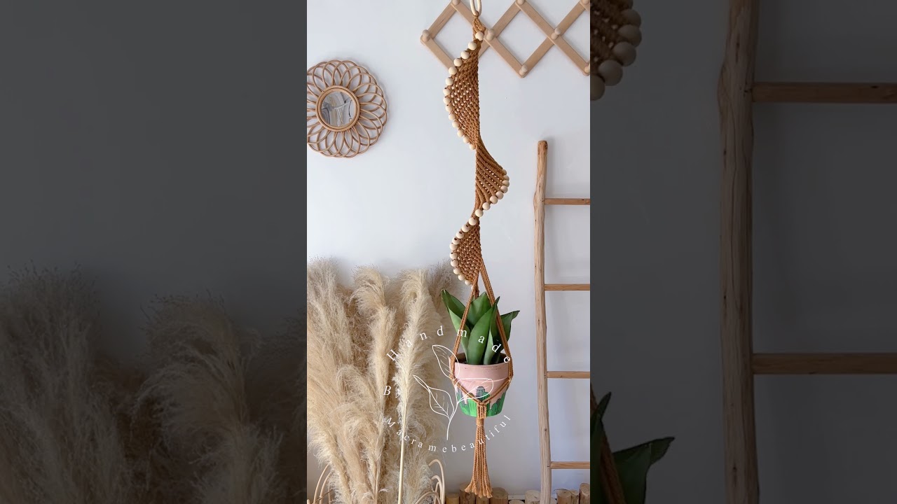 Spinning into botanical bliss with this long spiral macrame plant hanger adorned with beads