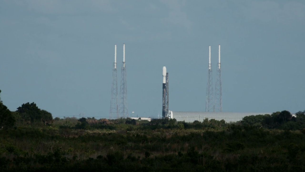NASA&rsquo;s new Moon rocket, inside its barge, cruises by a Falcon 9 rocket on the launch pad