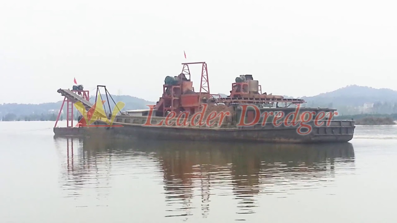 Bucket dredger and transport ship at work