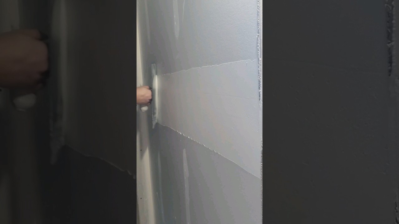 Drywall finisher applying his first coat with a 14