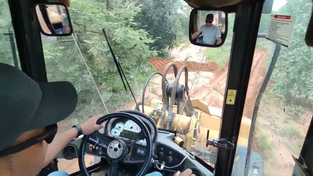 pá carregadeira tirando água da estrada