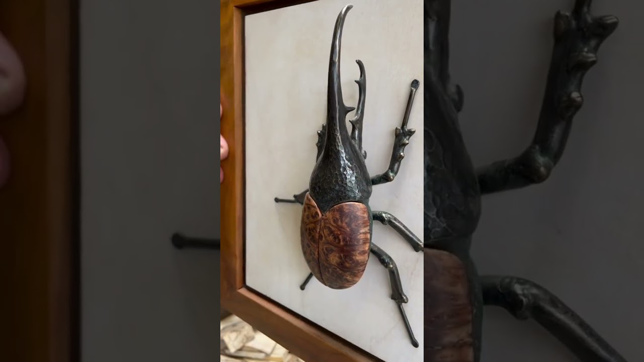 A Hercules Beetle made out bronze and lace redwood burl.
