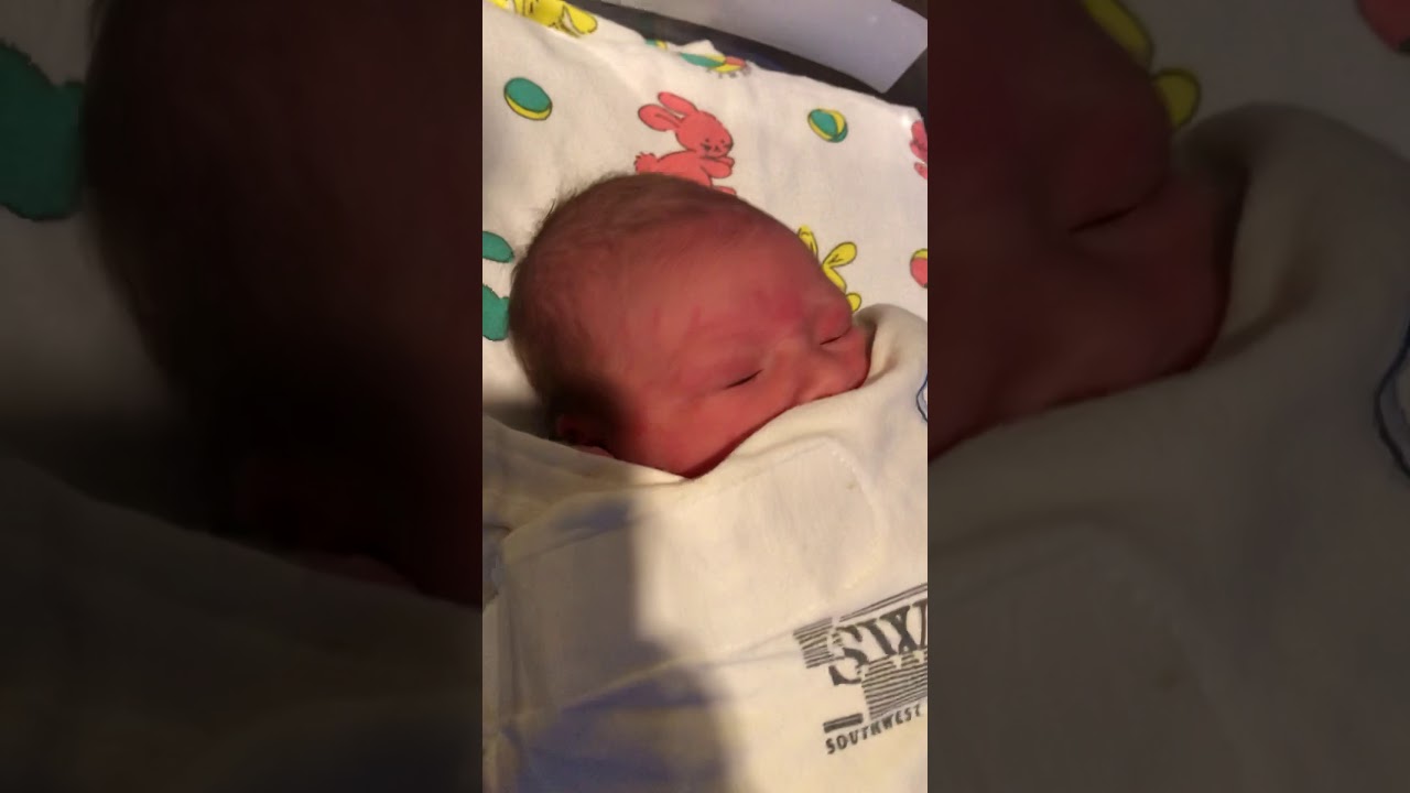 Cute newborn baby sneezes in hospital