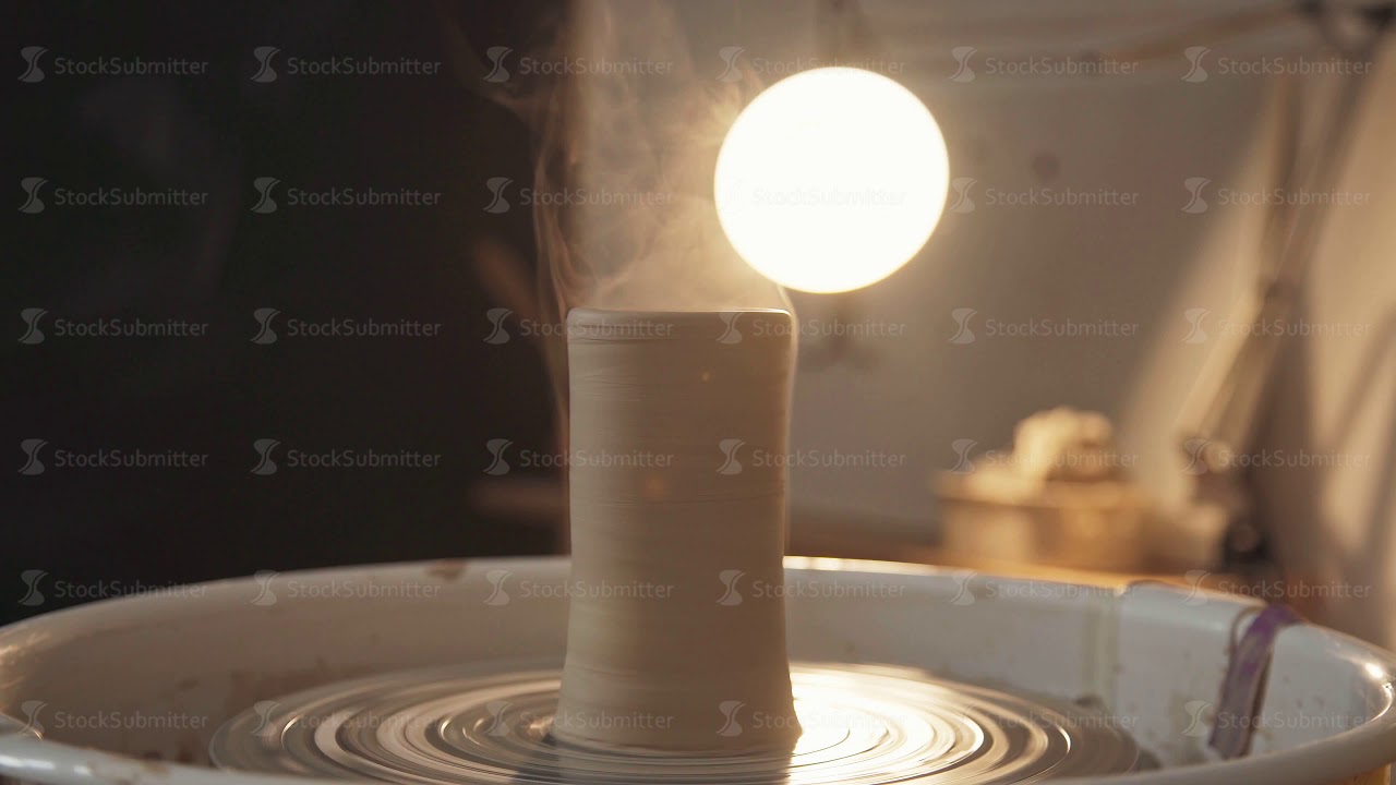 Pottery studio - clay ware on the potter's wheel, dark background