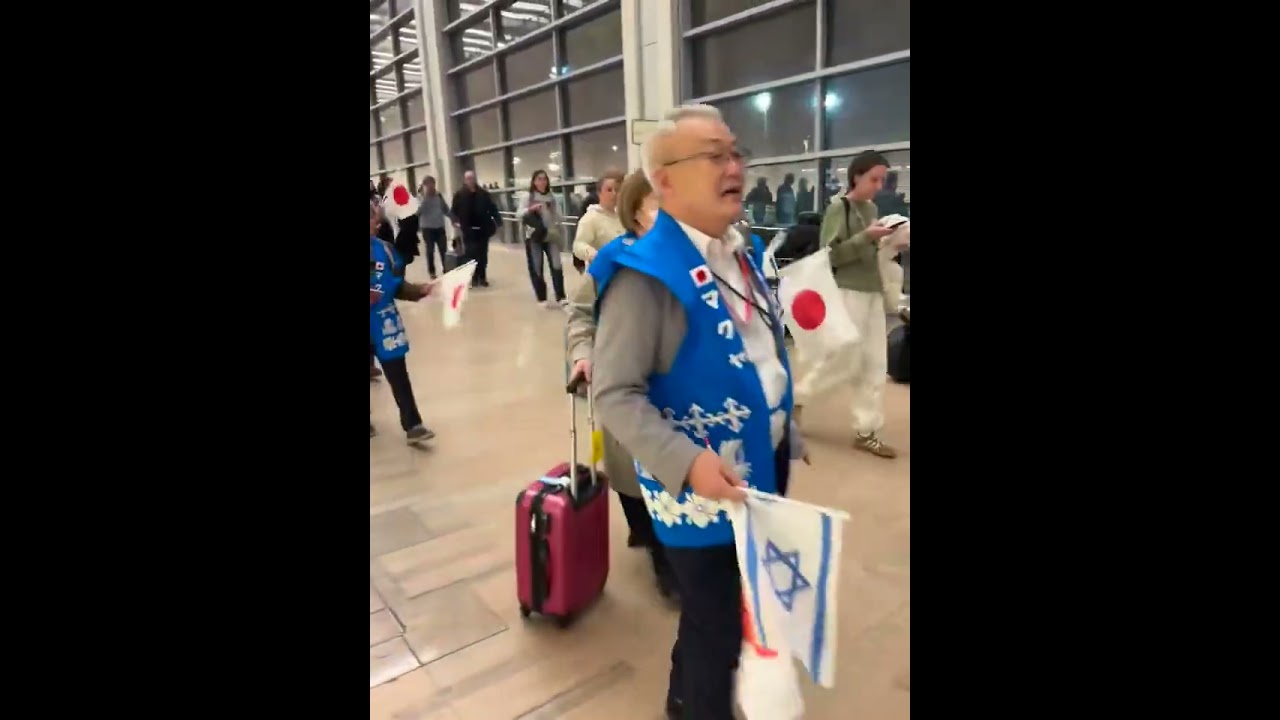 A group of Japanese Christians land in Israel with matching Israeli vests  singing Am Yisrael Chai
