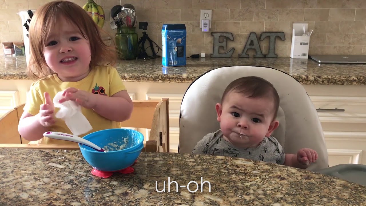 Big Sister feeds baby brother
